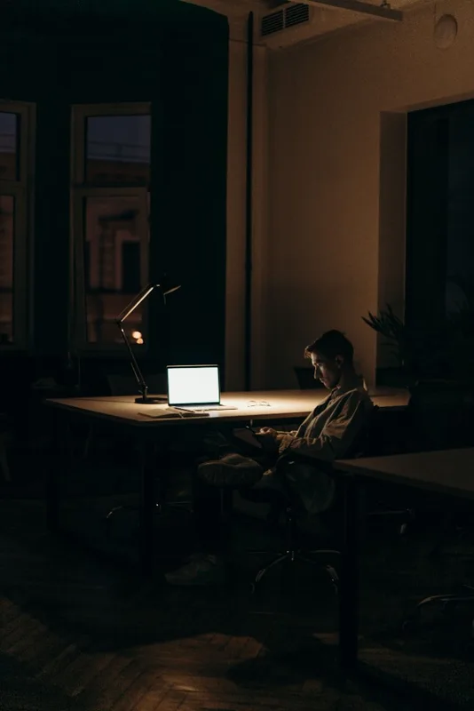 Founder working late on a laptop in a dim office