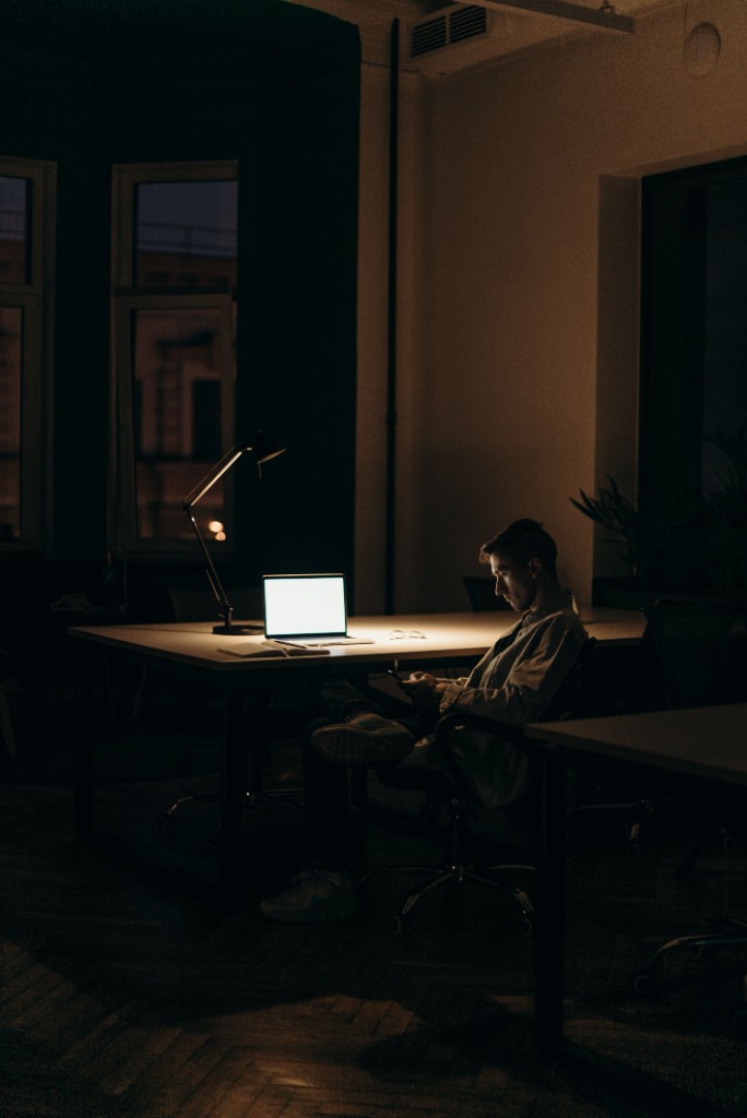 Founder working late on a laptop in a dim office