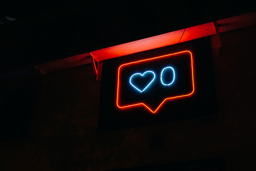 Neon sign showing zero likes on social media